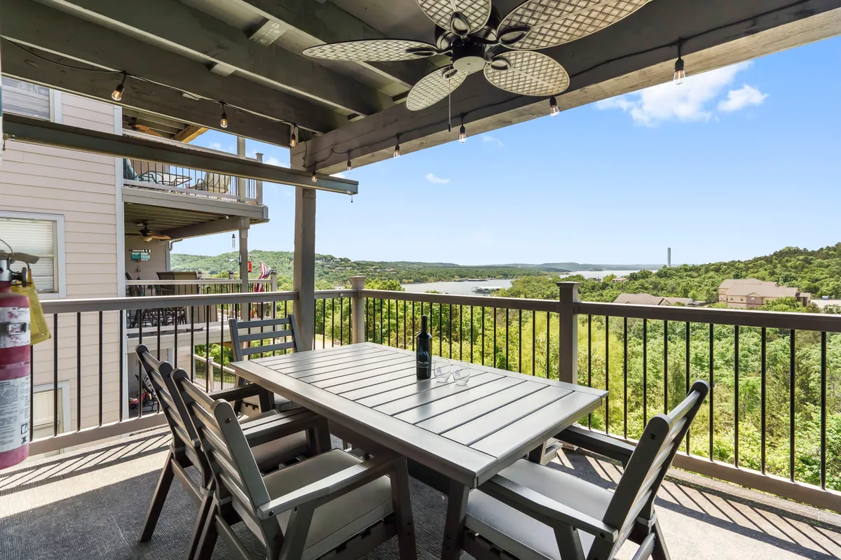 This exterior scene showcases a lakeside dining table set with a bottle of wine, perfectly positioned to capture stunning views of the water and surrounding landscape. The ambiance is relaxed and inviting, ideal for romantic al fresco meals or enjoying sunset drinks together.