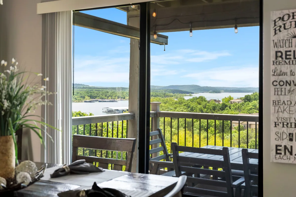 The dining table is set beside large windows or a balcony, offering diners unobstructed views of the lush landscape and water. The serene atmosphere is ideal for enjoying meals while soaking in the beauty of the outdoors, echoing the theme of memorable dining experiences with a lake view.