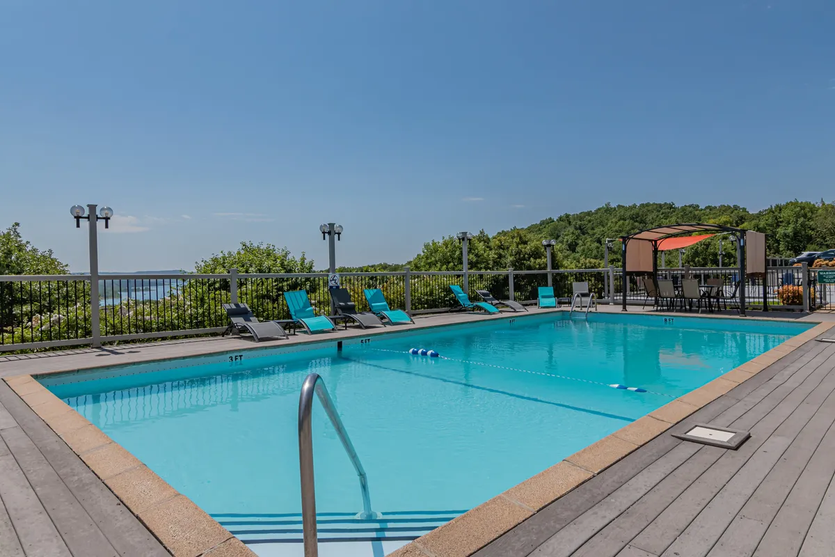 An inviting outdoor pool surrounded by lounge chairs and offering a clear view of the landscape beyond. The setting suggests a resort-style atmosphere ideal for swimming, sunbathing, and social gatherings.