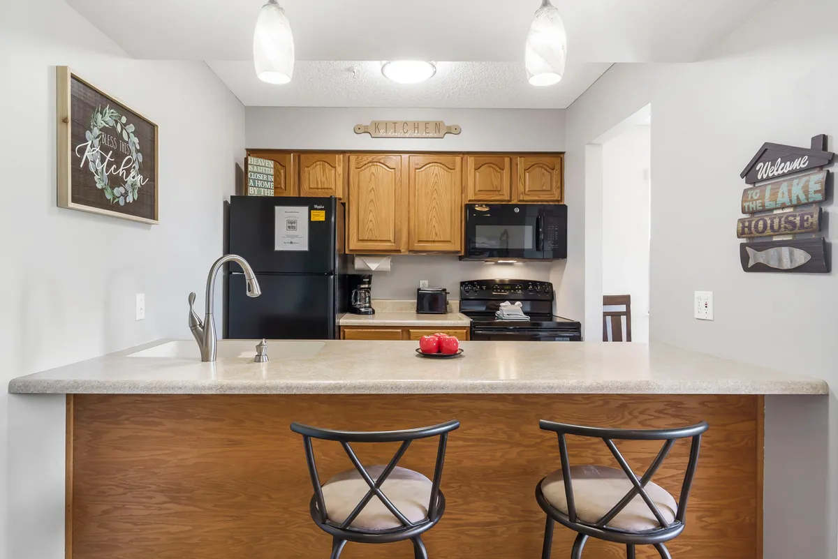 A modern kitchen scene with a central island, brand-new appliances, and decorative touches. The layout is designed for cooking and entertaining, with ample counter space and contemporary finishes, highlighting the recent updates emphasized in the section.